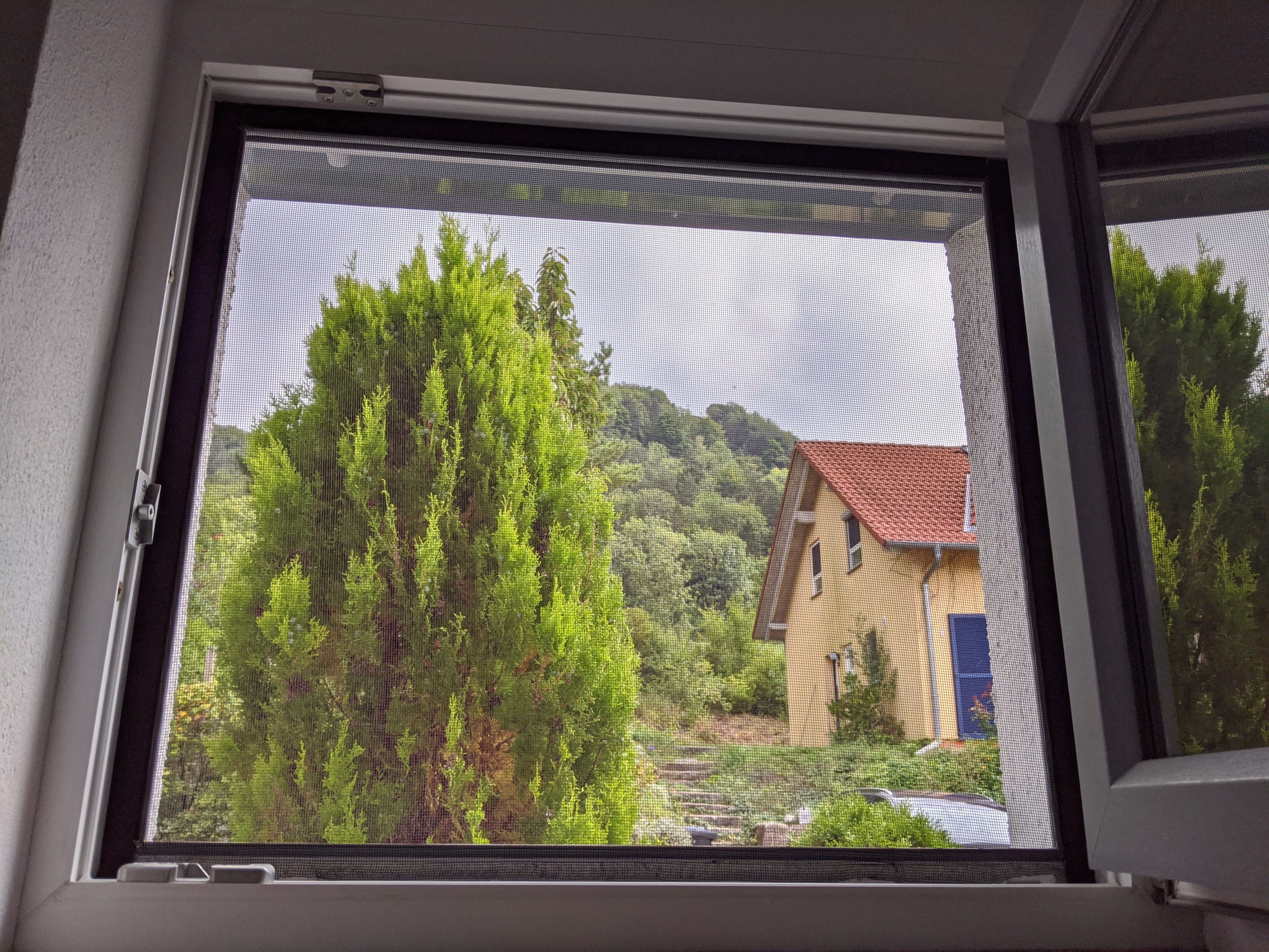 Innenansicht eines offenem, mit der Sonnenschutzfolie silber mittel verspiegelt beklebtem Fensters Innenansicht eines offenem, mit der Sonnenschutzfolie silber mittel verspiegelt beklebtem Fensters