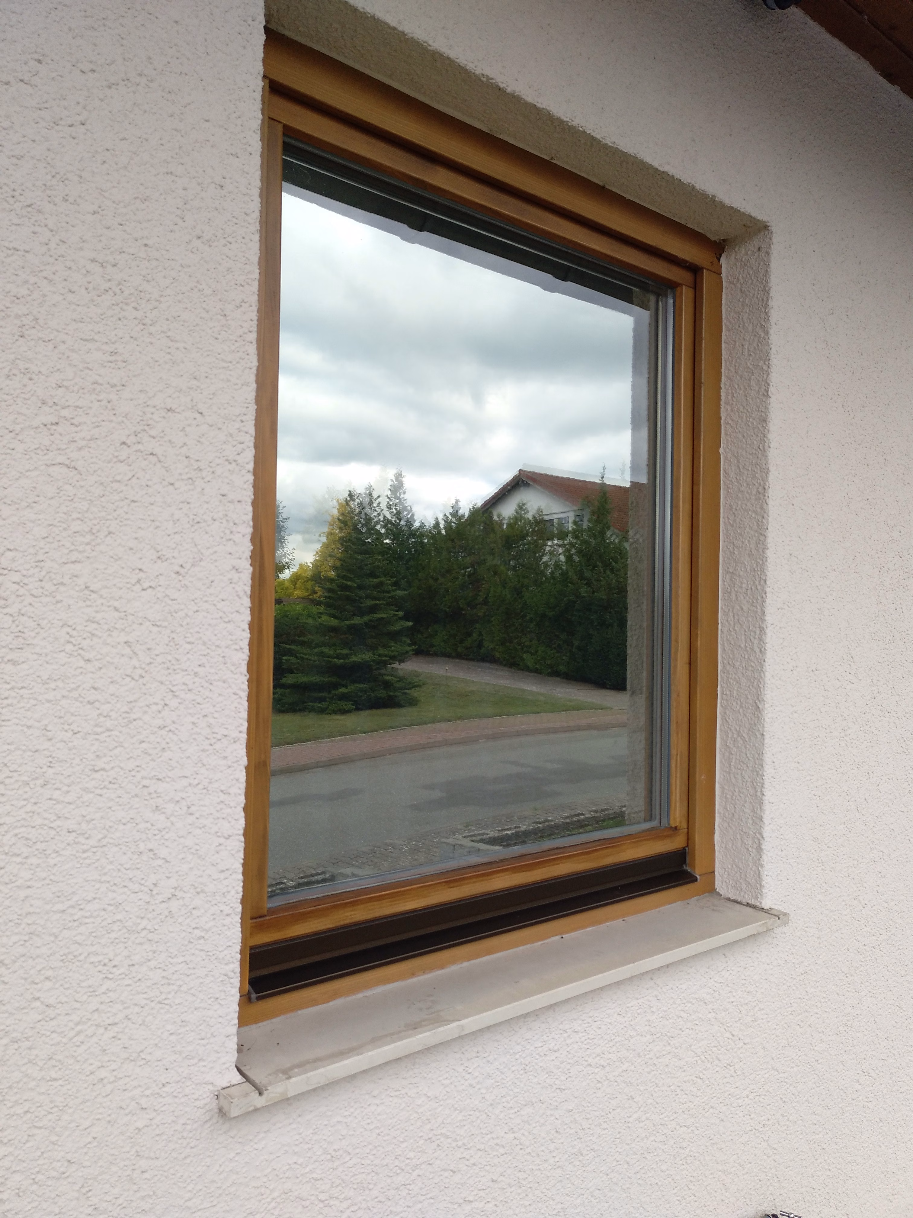 Silberne Spionspiegelfolie vollflächig auf Holzfenster foliert