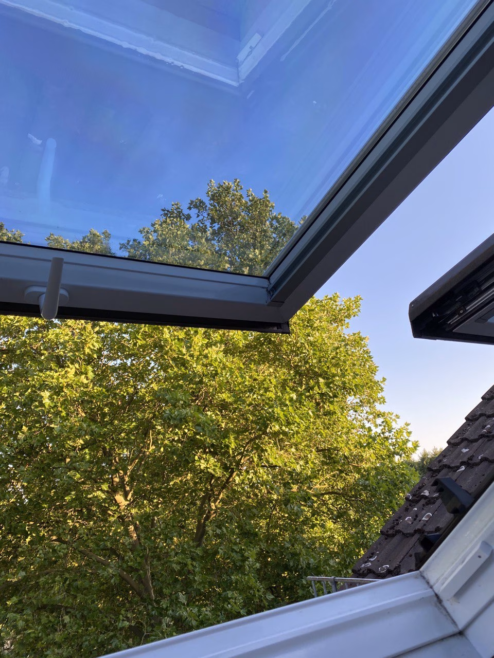 Silber dunkle Sonnenschutzfolie auf einem Dachfenster angebracht Silber dunkle Sonnenschutzfolie auf einem Dachfenster angebracht