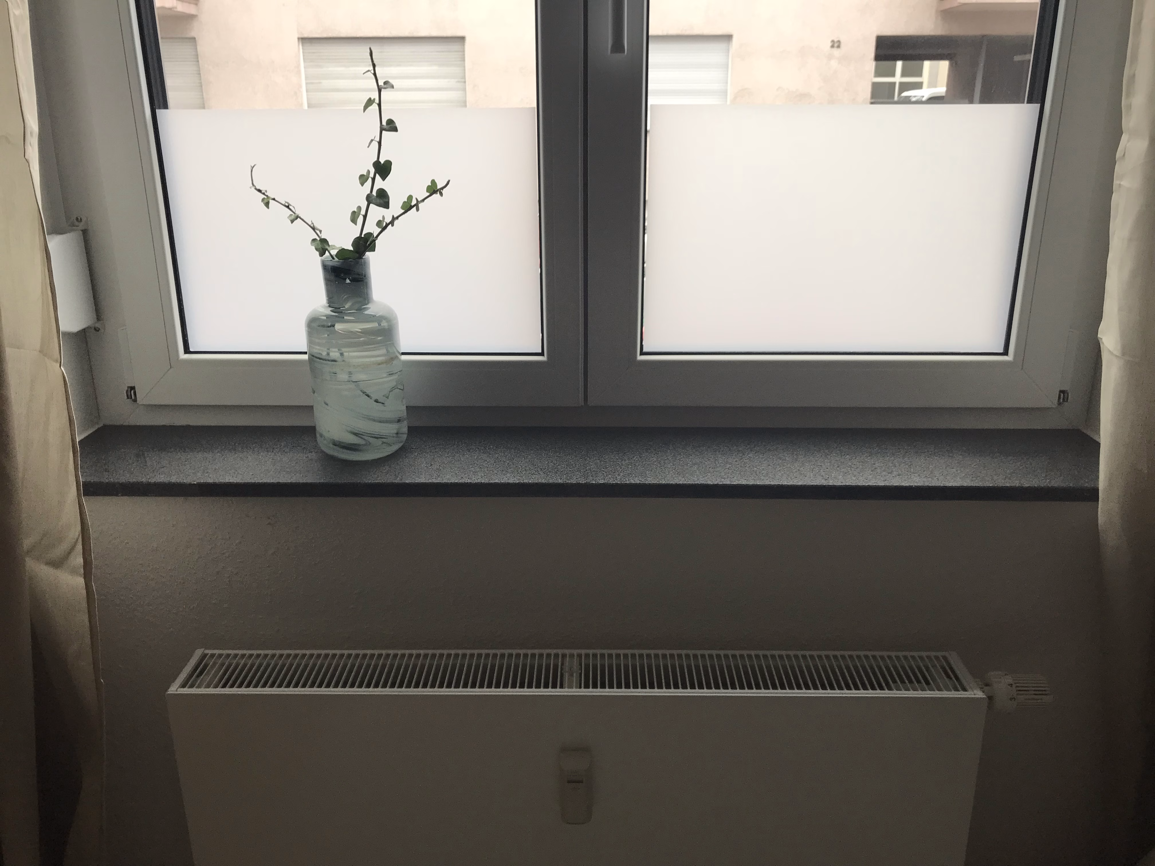 Mit Milchglasfolie halbhoch foliertes Fenster.