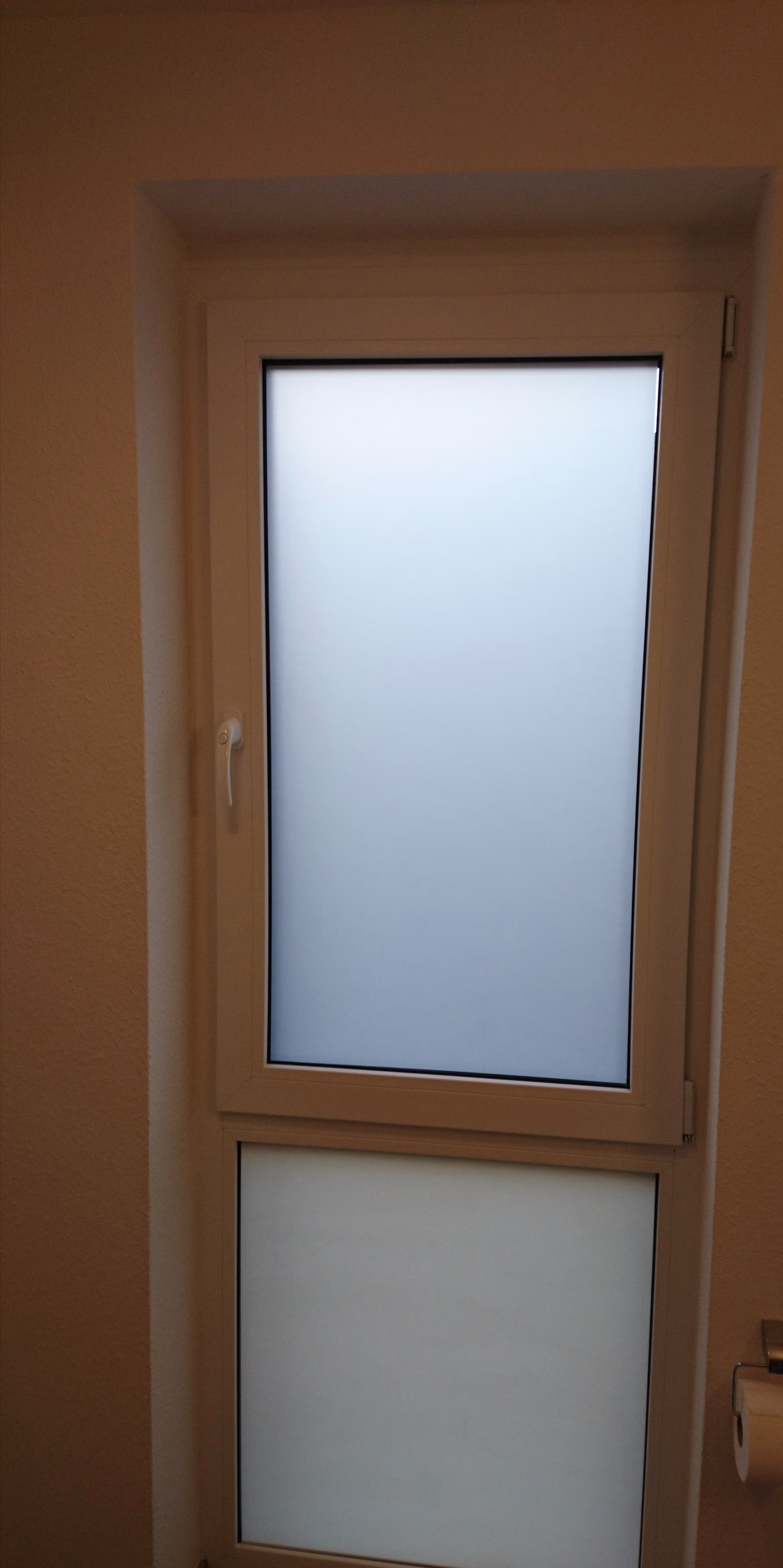 Milchglasfolie auf einem feststehenden Fenster als Sichtschutz montiert.