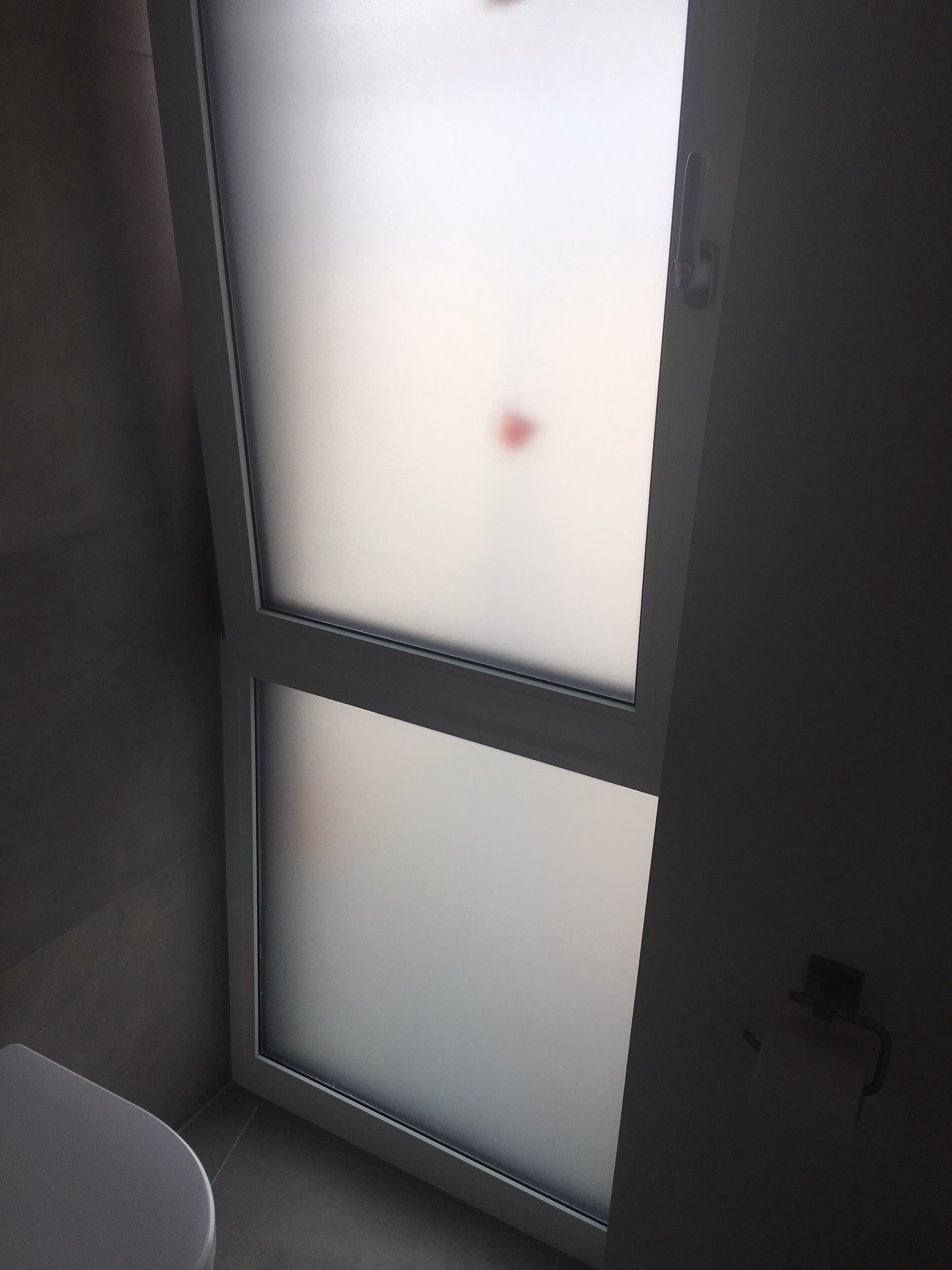 Kleberlose Folie auf einem Badezimmerfenster als Sichtschutz angebracht.