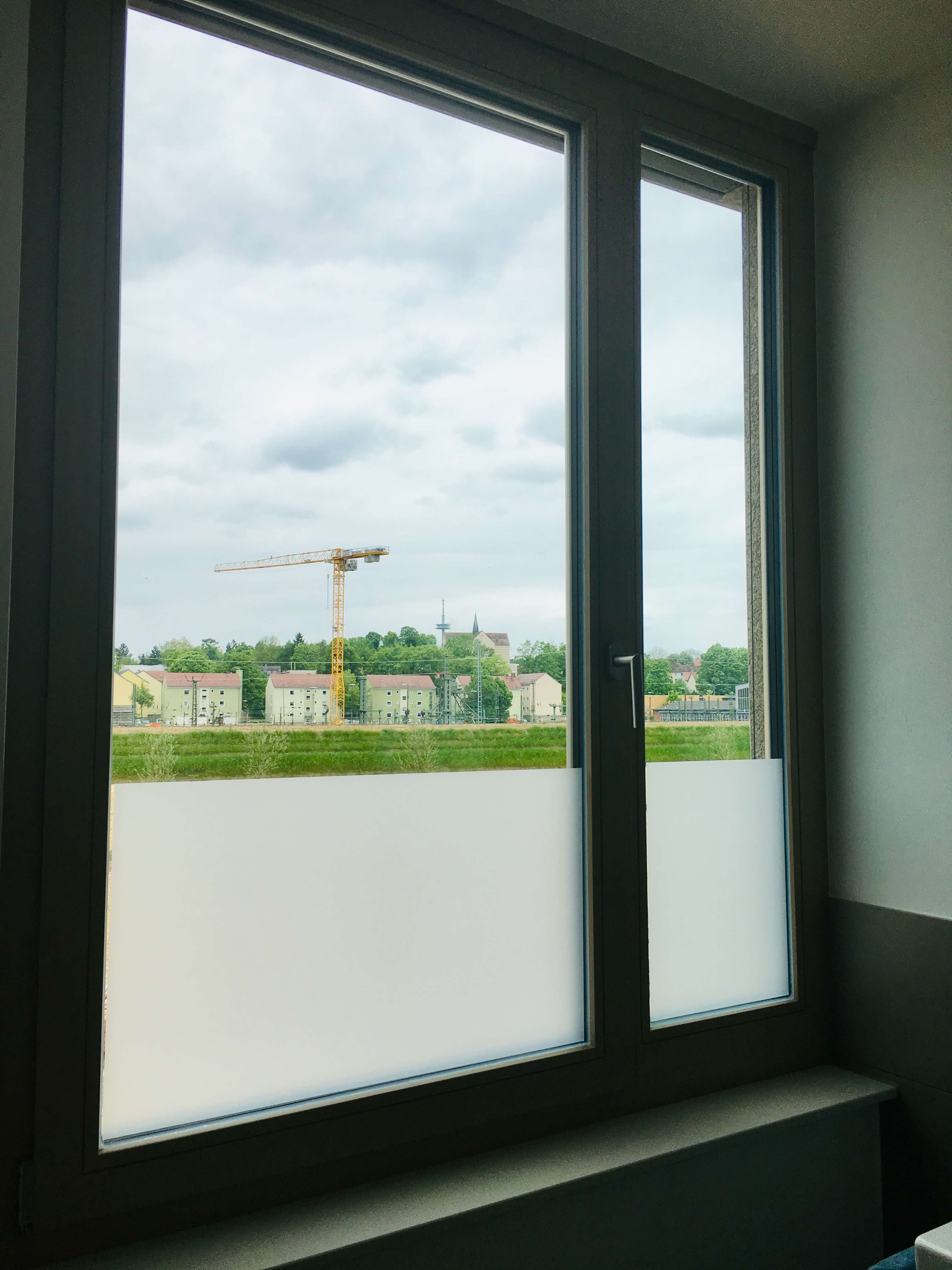 Moderner Sichtschutz durch Milchglasfolie im unteren Bereich eines Fensters.