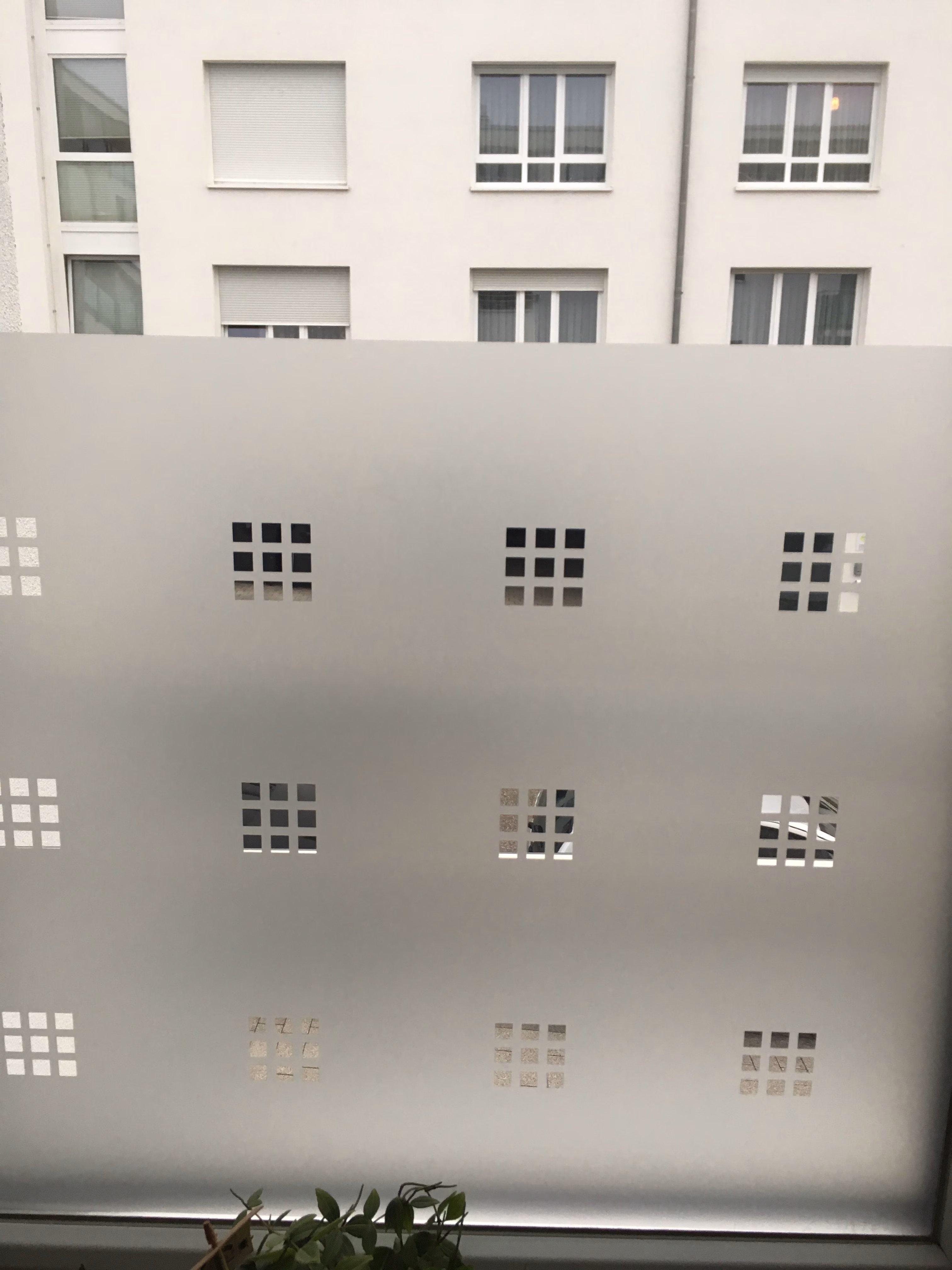 Dekorfolie transparente Quadrate im 9er Block auf einem Fenster montiert.
