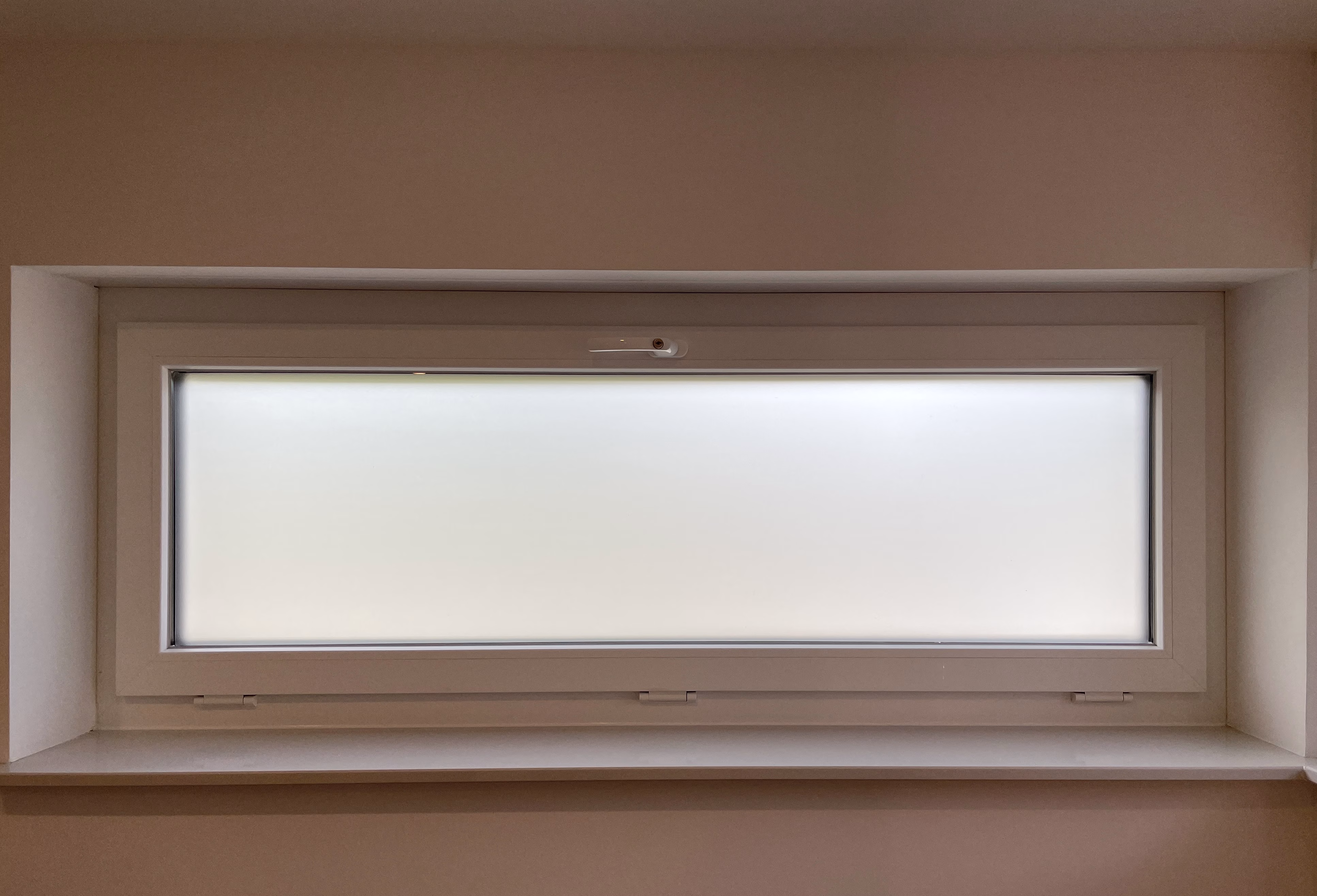 Selbsthaftende, matt weiße Sichtschutzfolie auf einem Badezimmerfenster