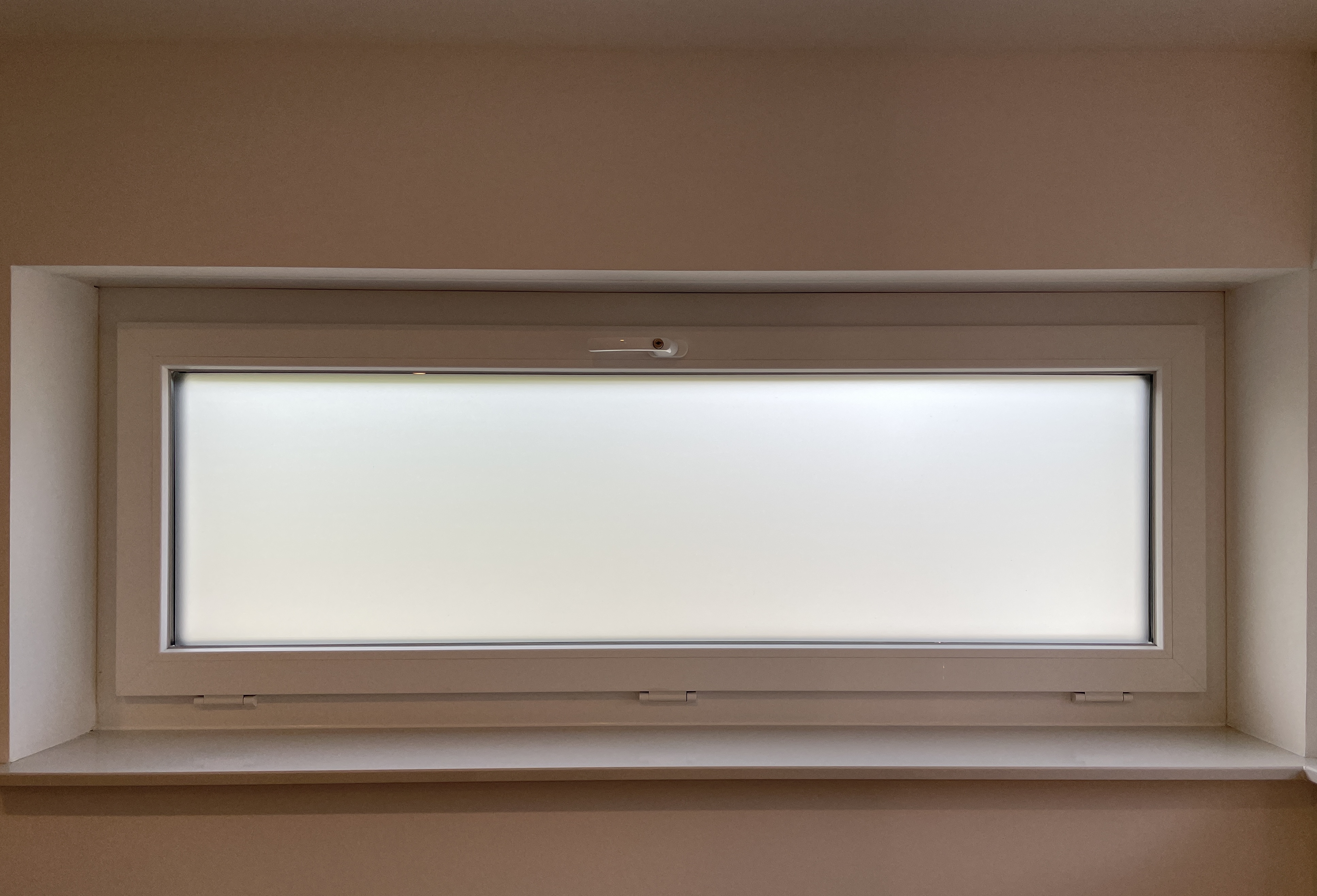 Selbsthaftende, matt weiße Sichtschutzfolie auf einem Badezimmerfenster