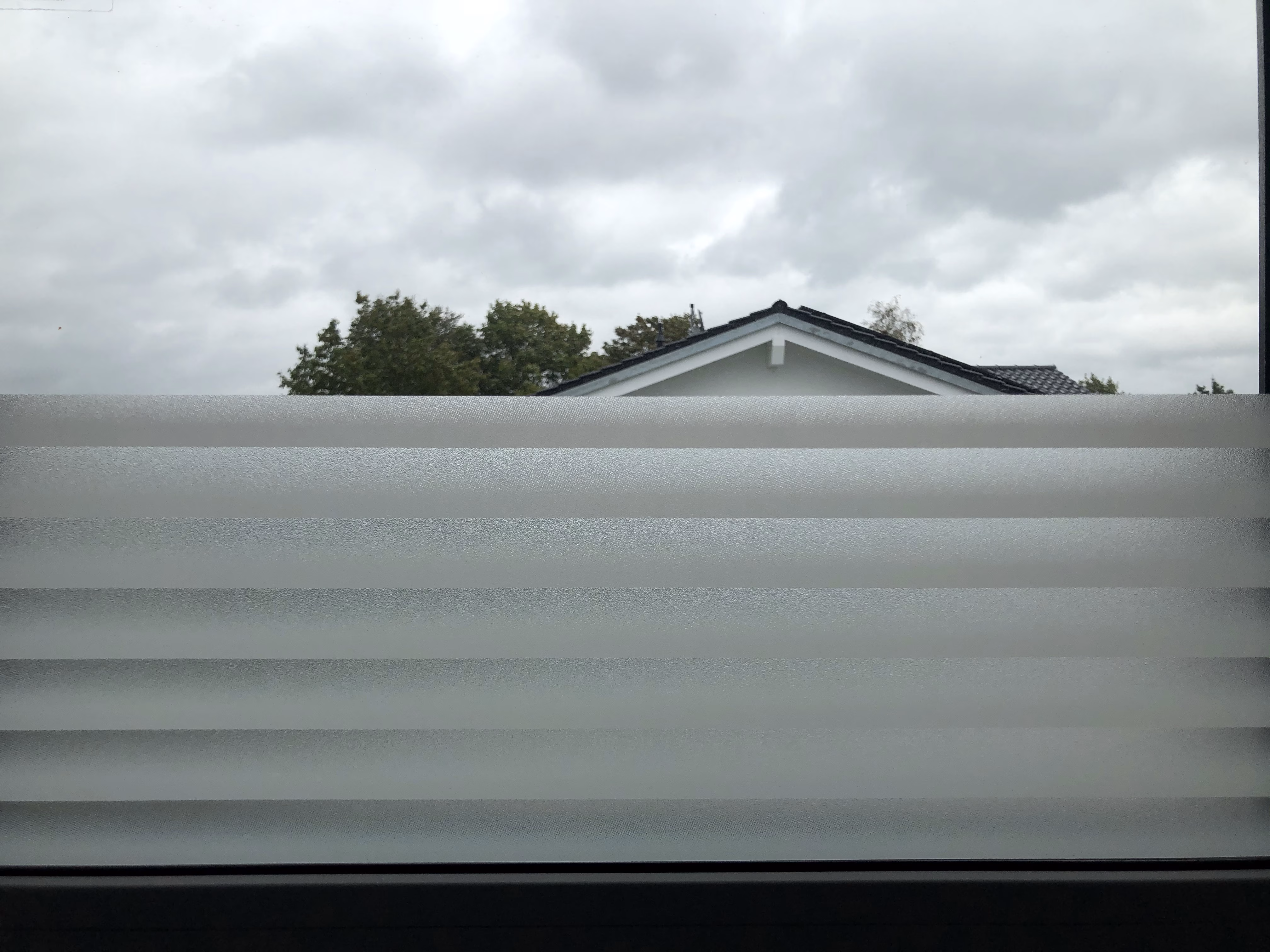 Selbsthaftende kleberlose Adhäsionsfolie im Streifendesign halbhoch auf Fenster montiert