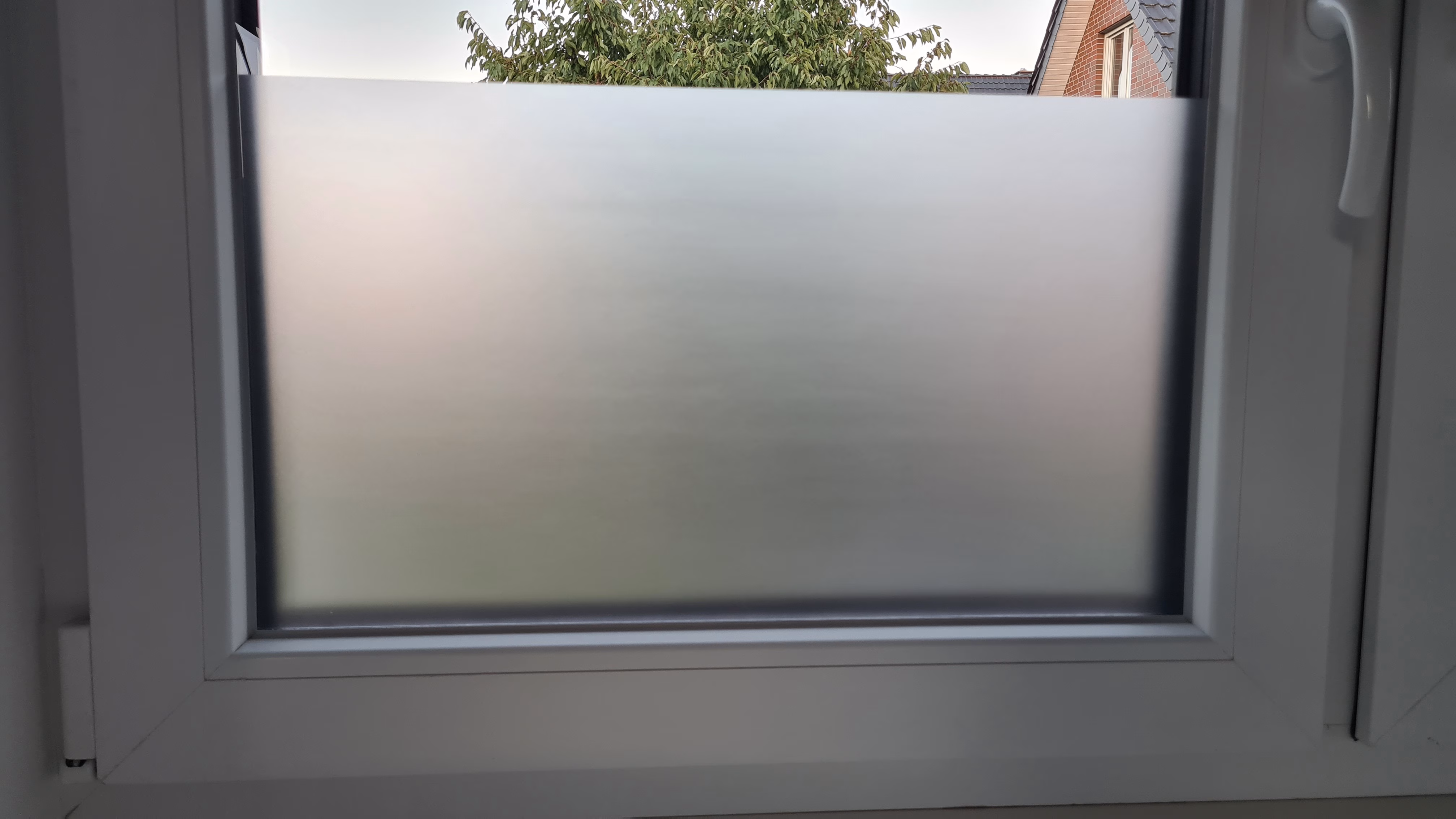 Selbsthaftende Sichtschutzfolie auf der unteren hälfte eines Fenster angebracht
