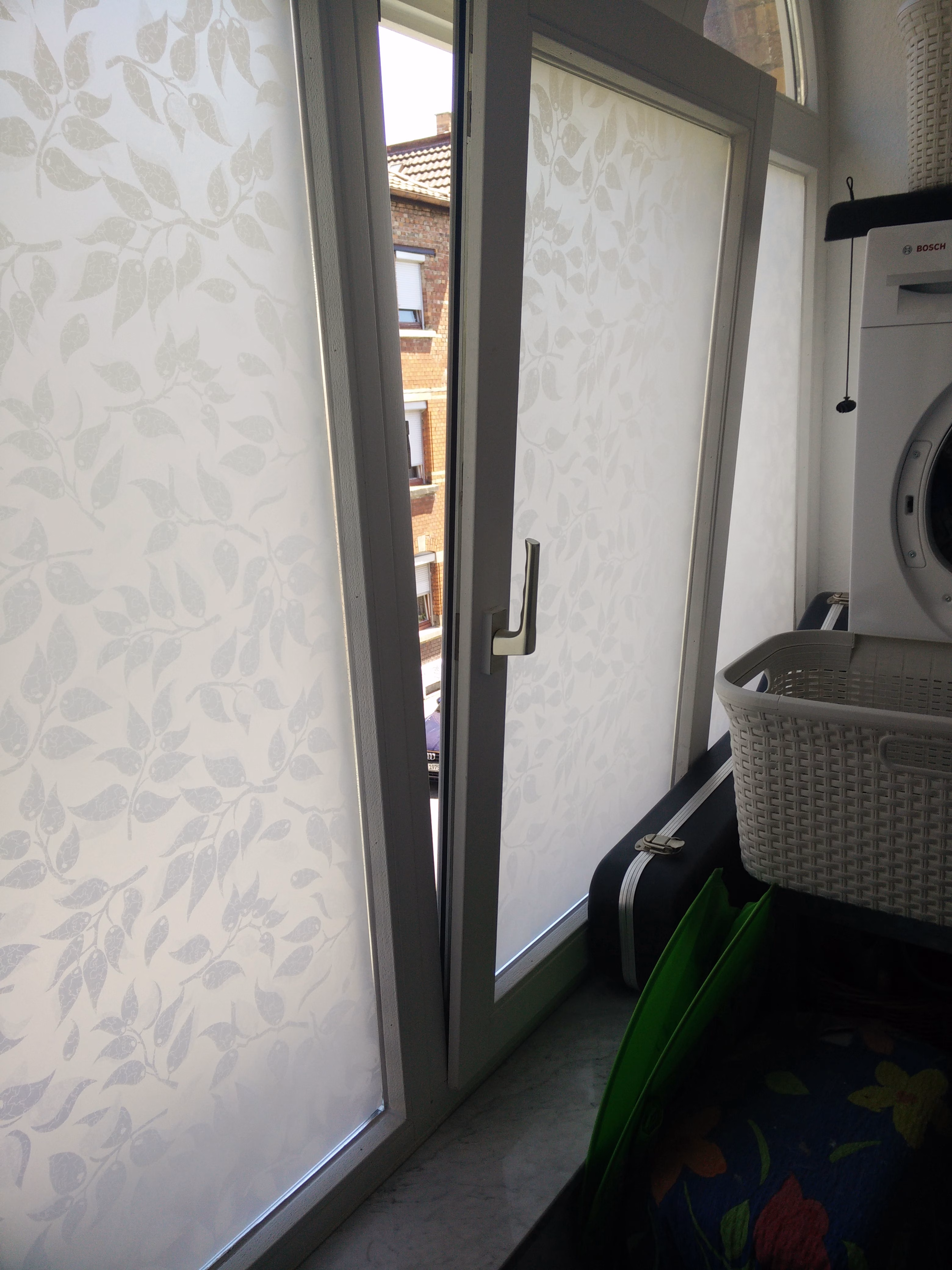 Sichtschutzfolie weiße Blätter auf weißem Grund auf einem Fenster angebracht