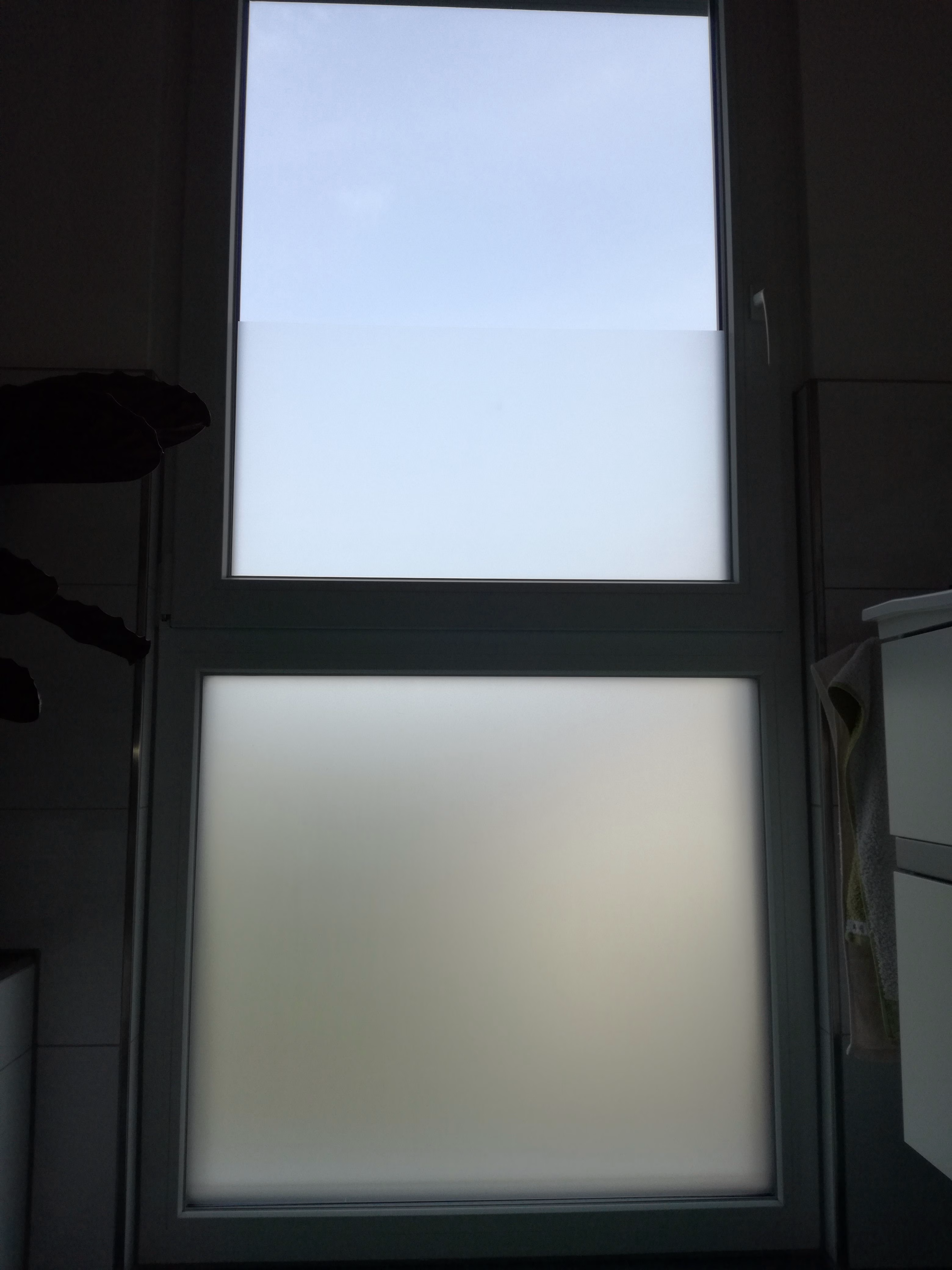 Selbsthaftende Sichtschutzfolie auf einem Badezimmerfenster angebracht.