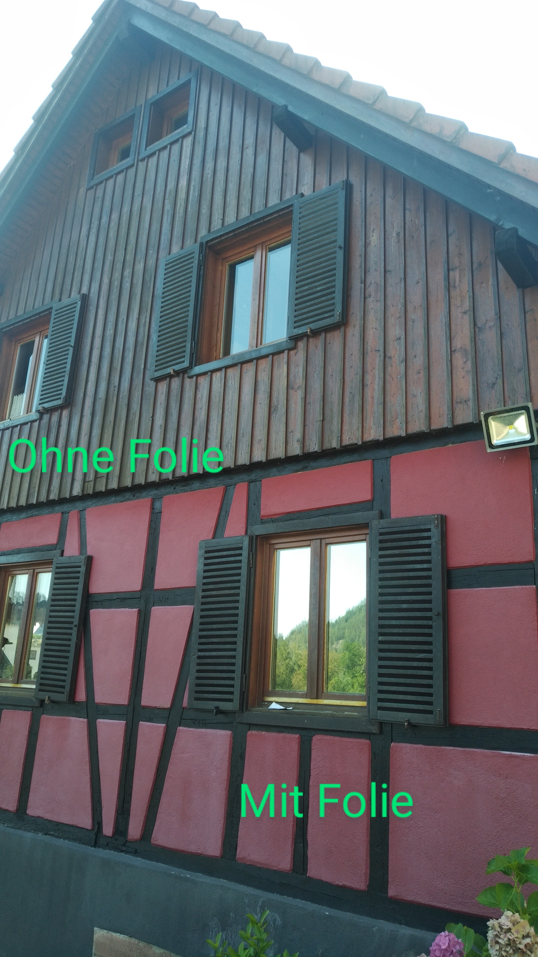 Mit Spionspiegelfolie folierte und unfolierte Fenster an einem Fachwerkhaus