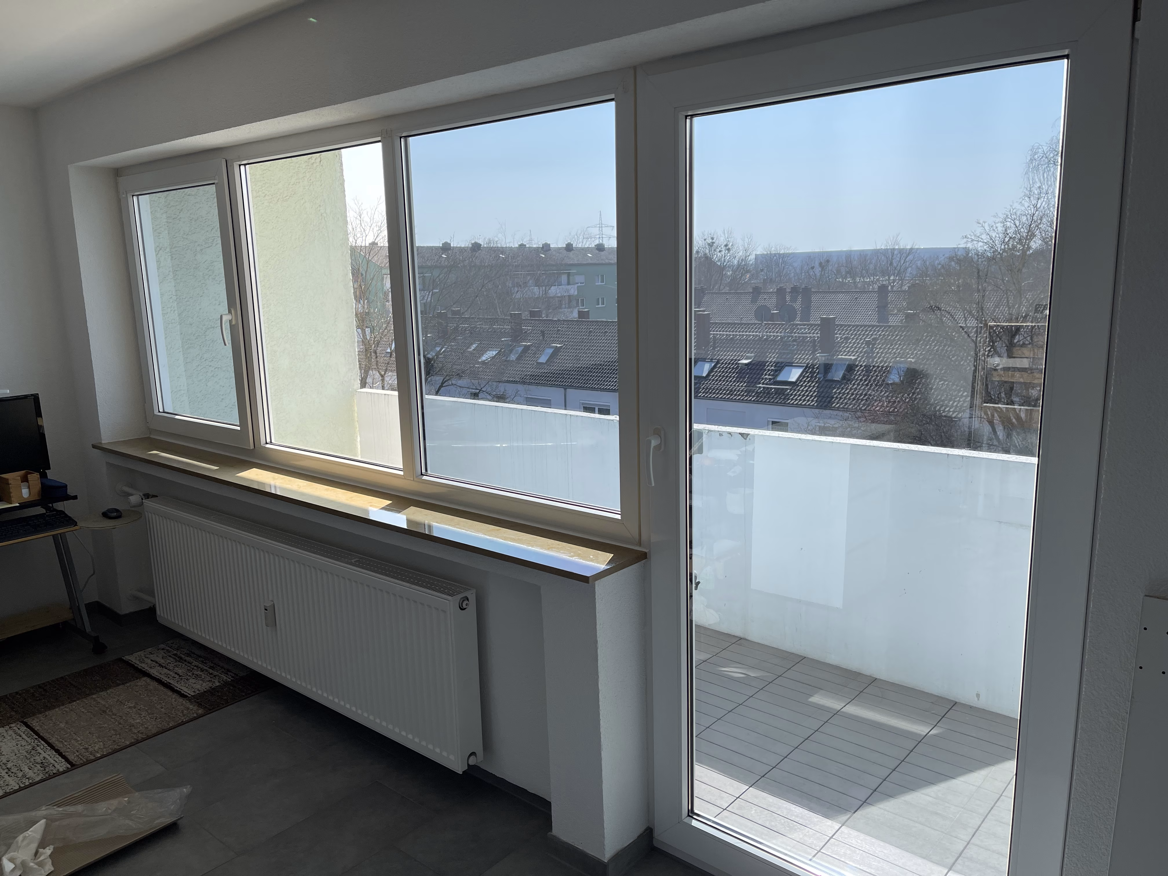 Sonnenschutzfolie, stark verspiegelt am Fenster eines Balkons