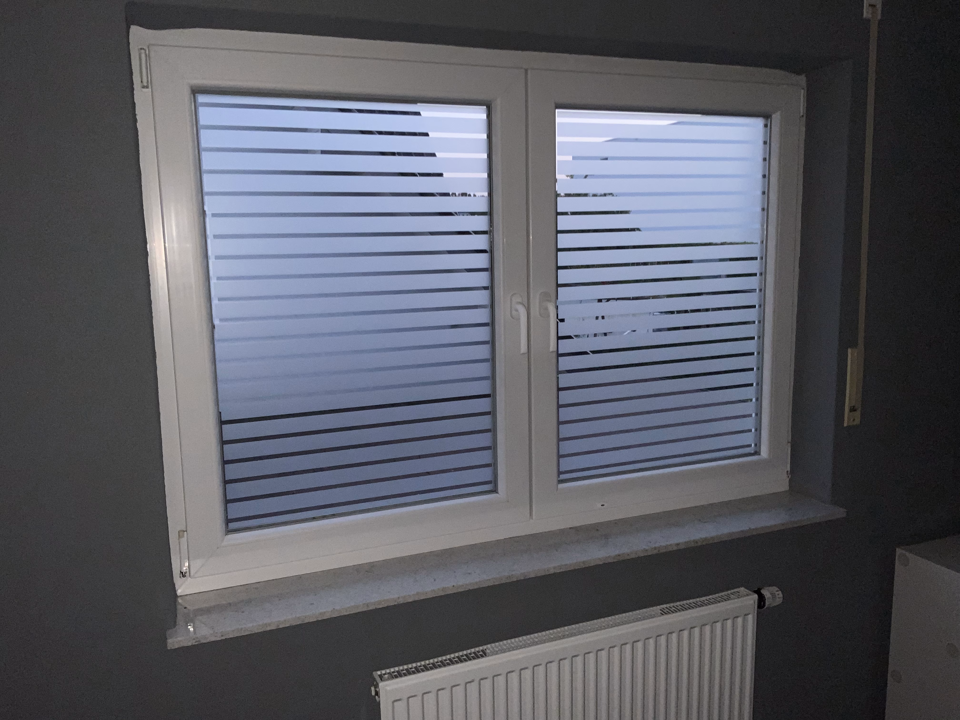 Weiße Streifenfolie auf dem ganzen Fenster verklebt