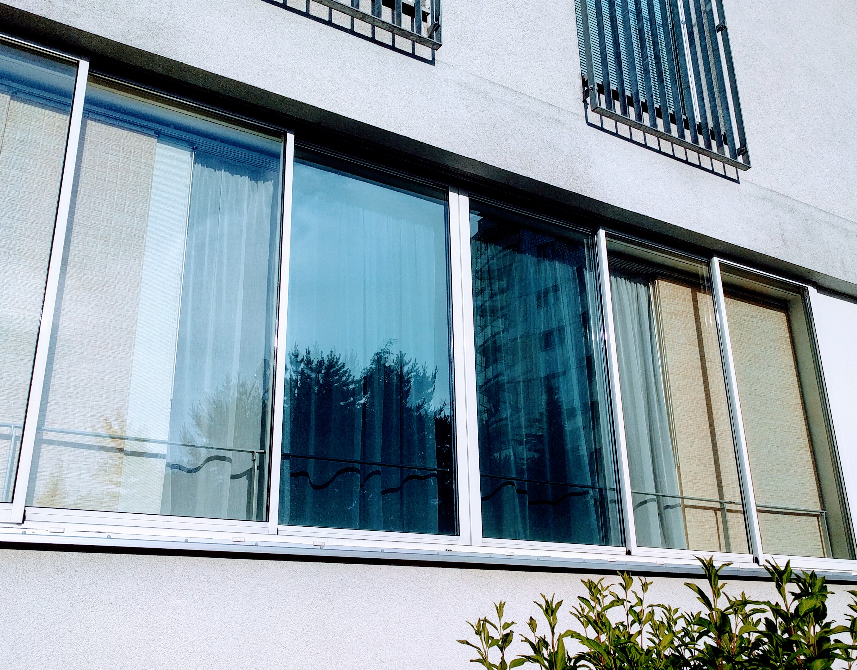 Sonnenschutzfolie silber mittel verspiegelt auf mehreren Loggia-Fenstern