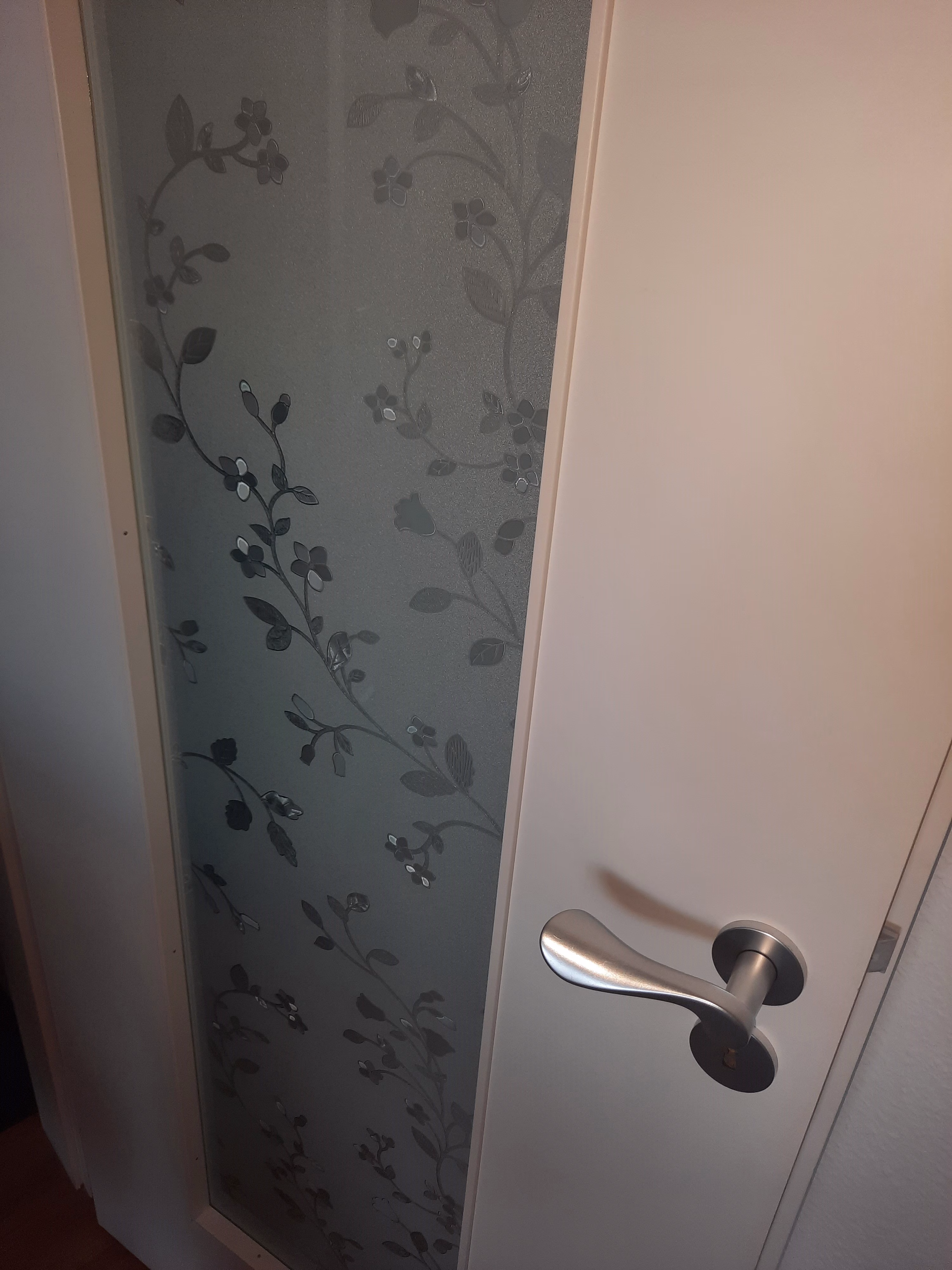 Lichtschlitz in Zimmertür mit selbsthaftender Folie im Design Blumenranken beklebt
