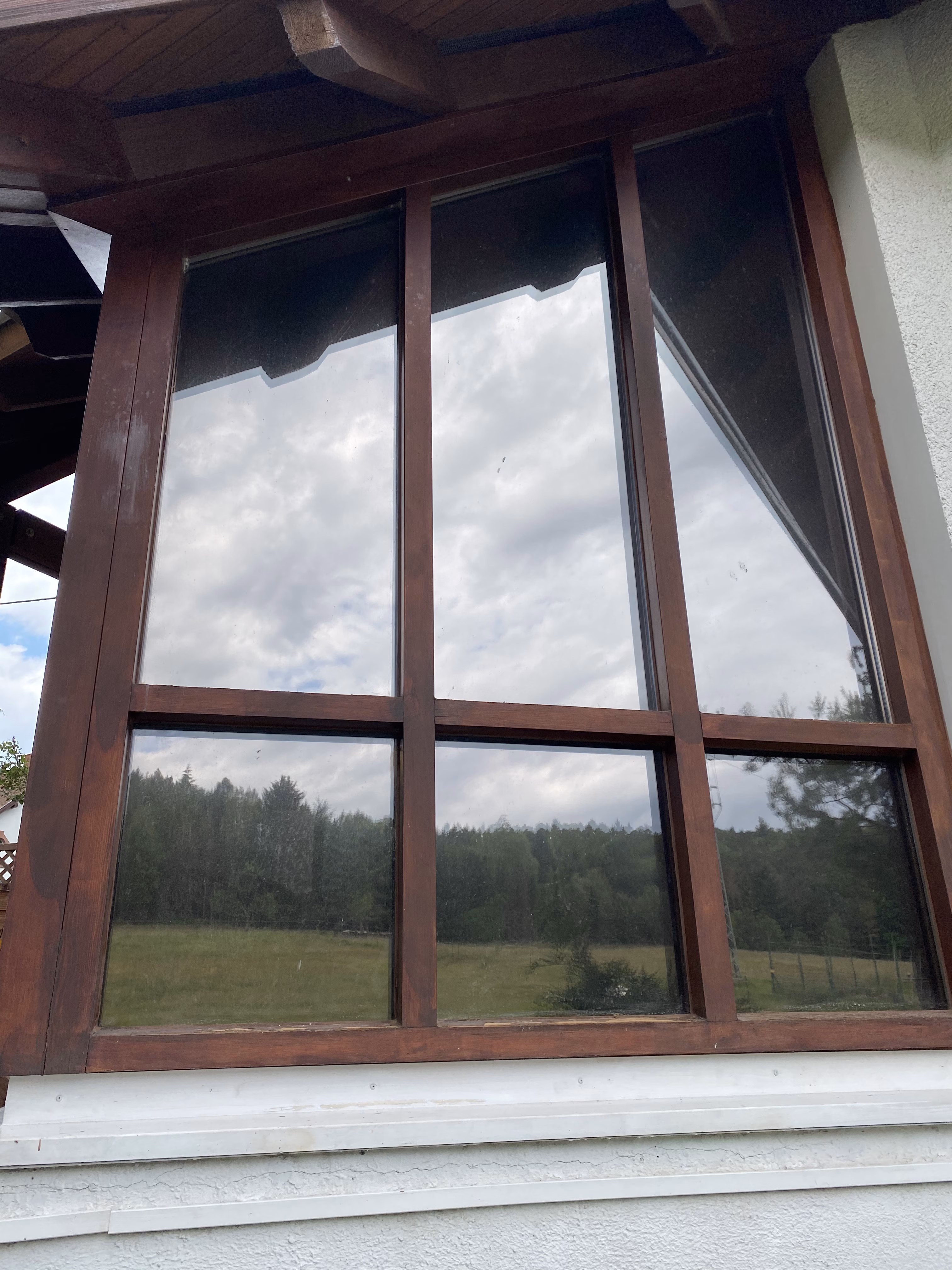 Spiegeleffekt der Sonnenschutzfolie bronze dunkel verspiegelt an großen Fenstern.