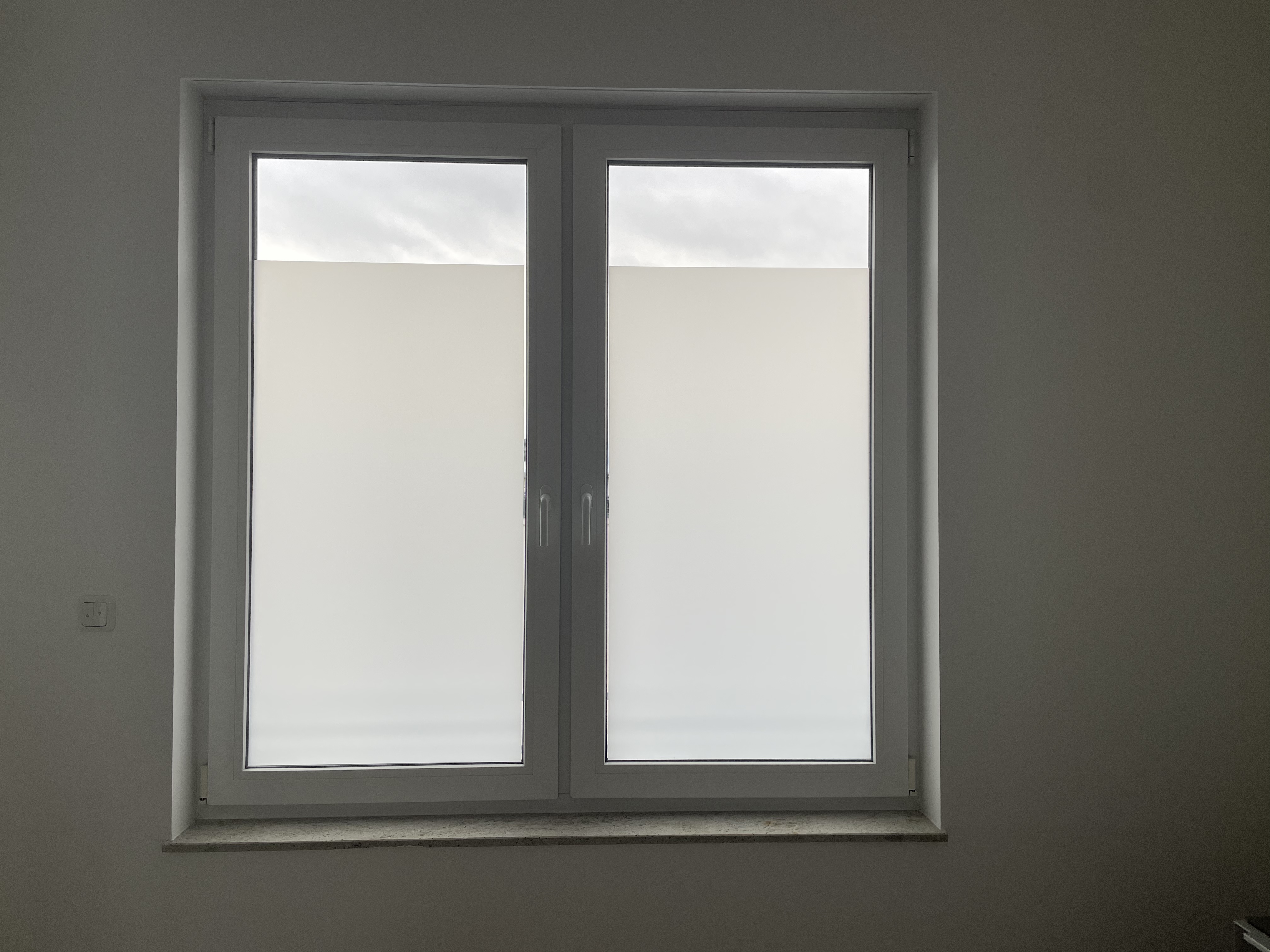 Weiße Milchglasfolie auf einem Doppelfenster