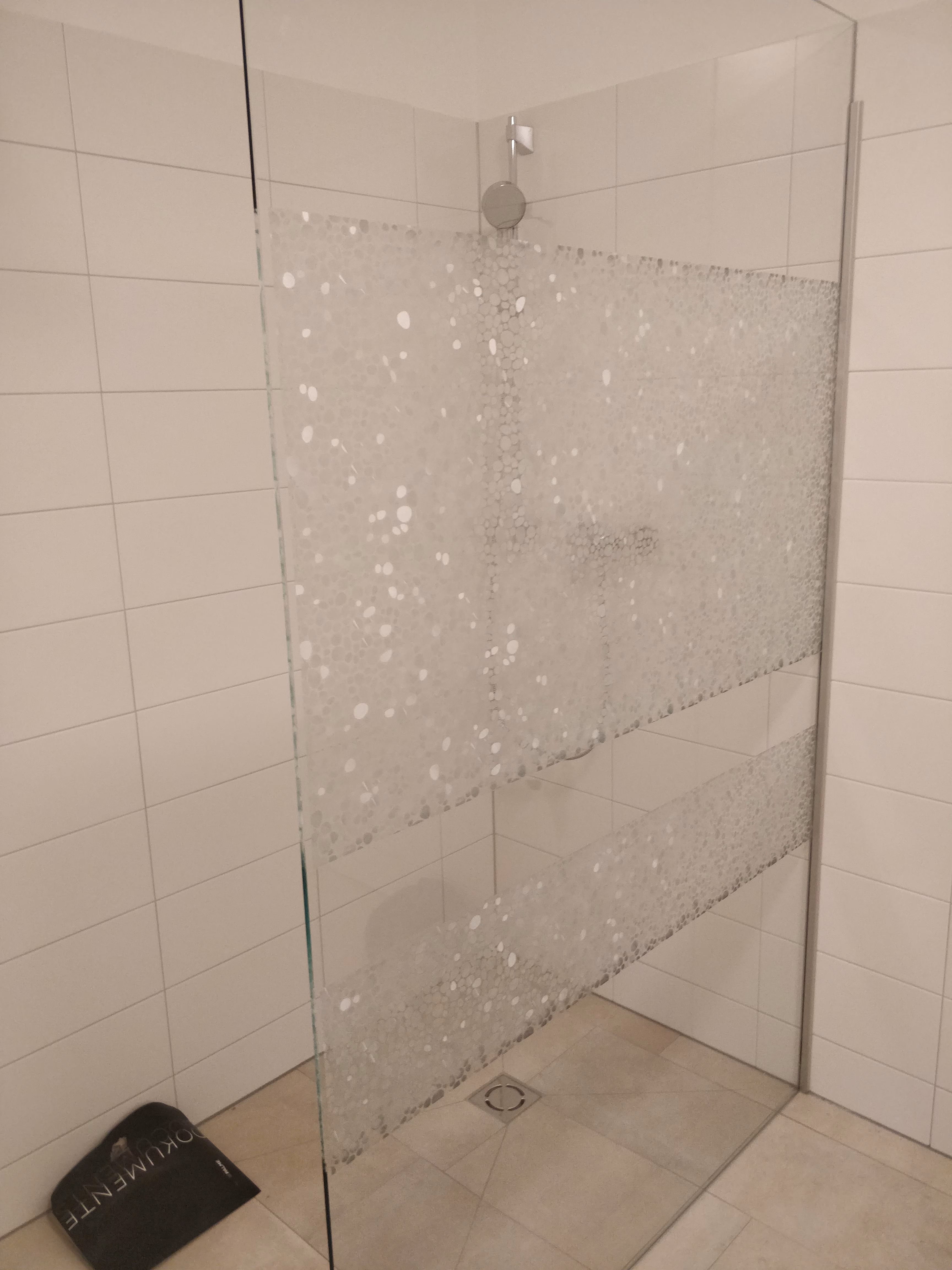 Dekorfolie in Perlenoptik auf einer Duschtrennwand