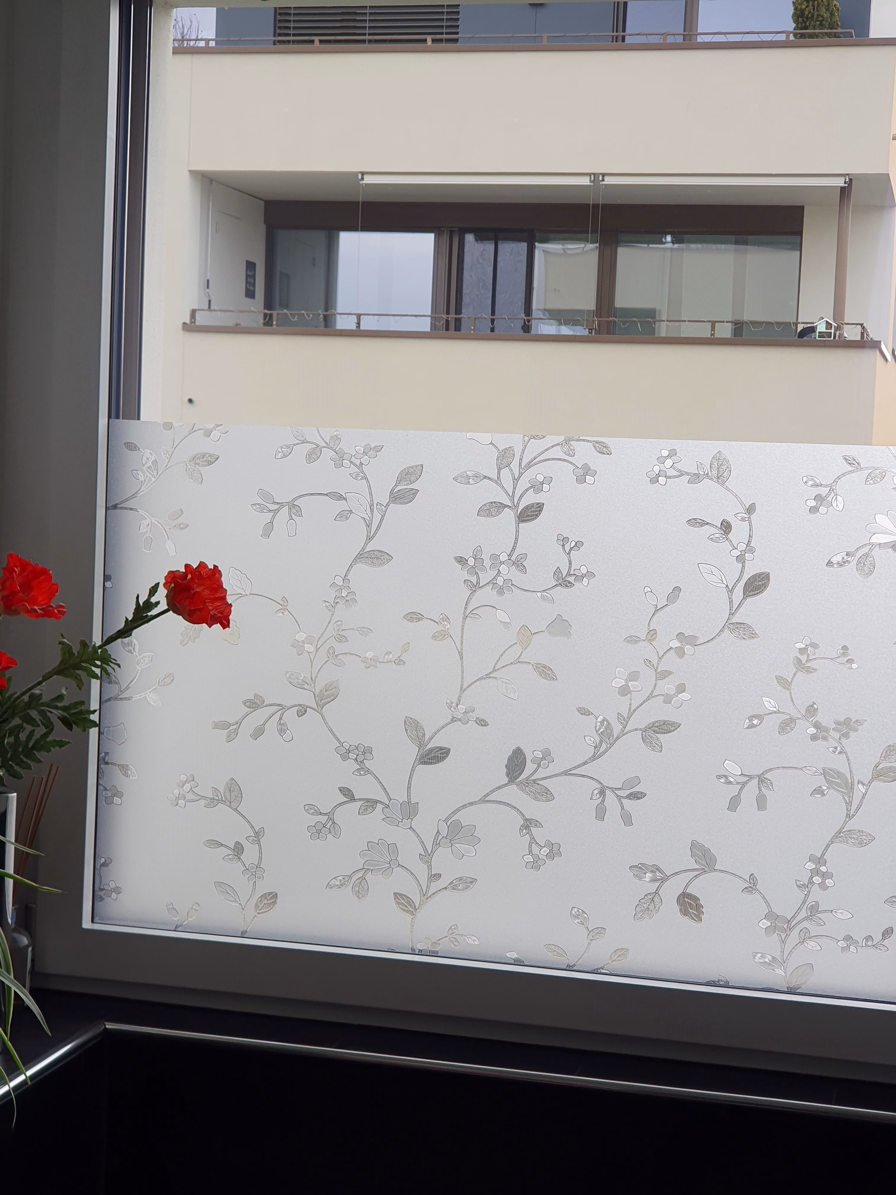 Detailaufnahmen der Adhäsionsfolie mit Blumenranken auf einem Fenster