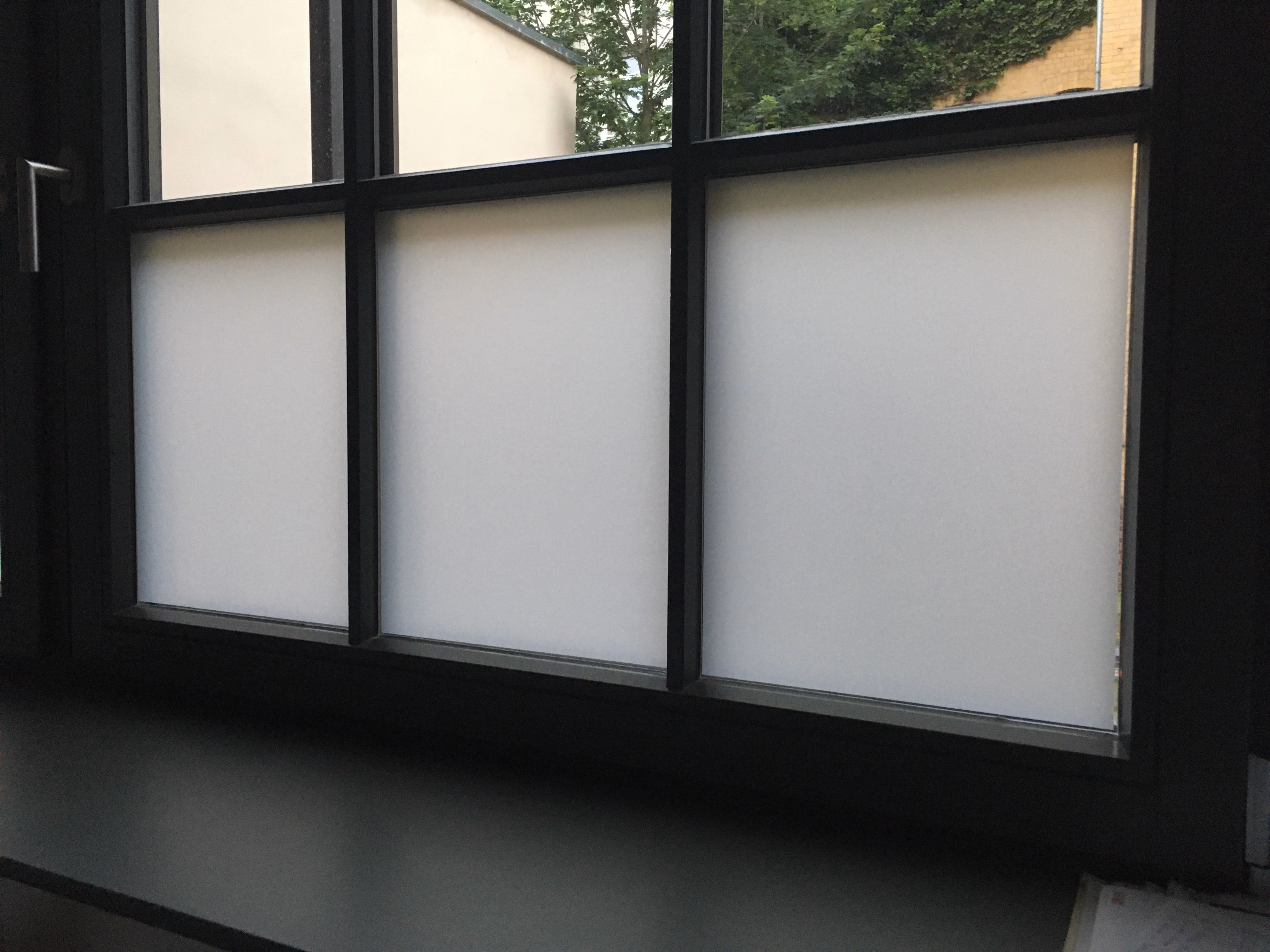 Weiße Milchglasfolie passgenau im unteren Bereich eines Sprossenfensters angebracht