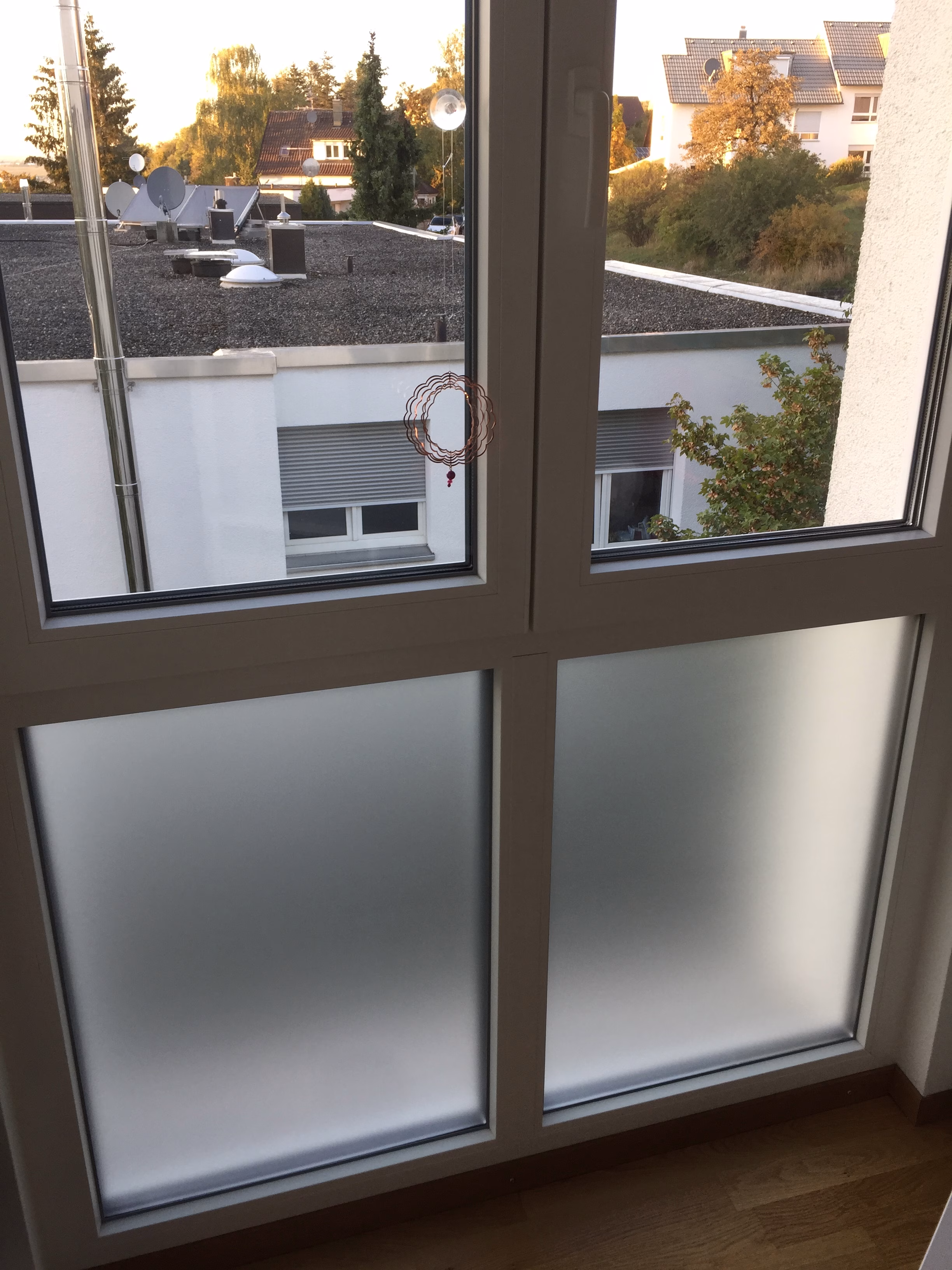 Weiß matte Adhäsionsfolie auf dem unteren Teil einer Fensterfront angebracht.