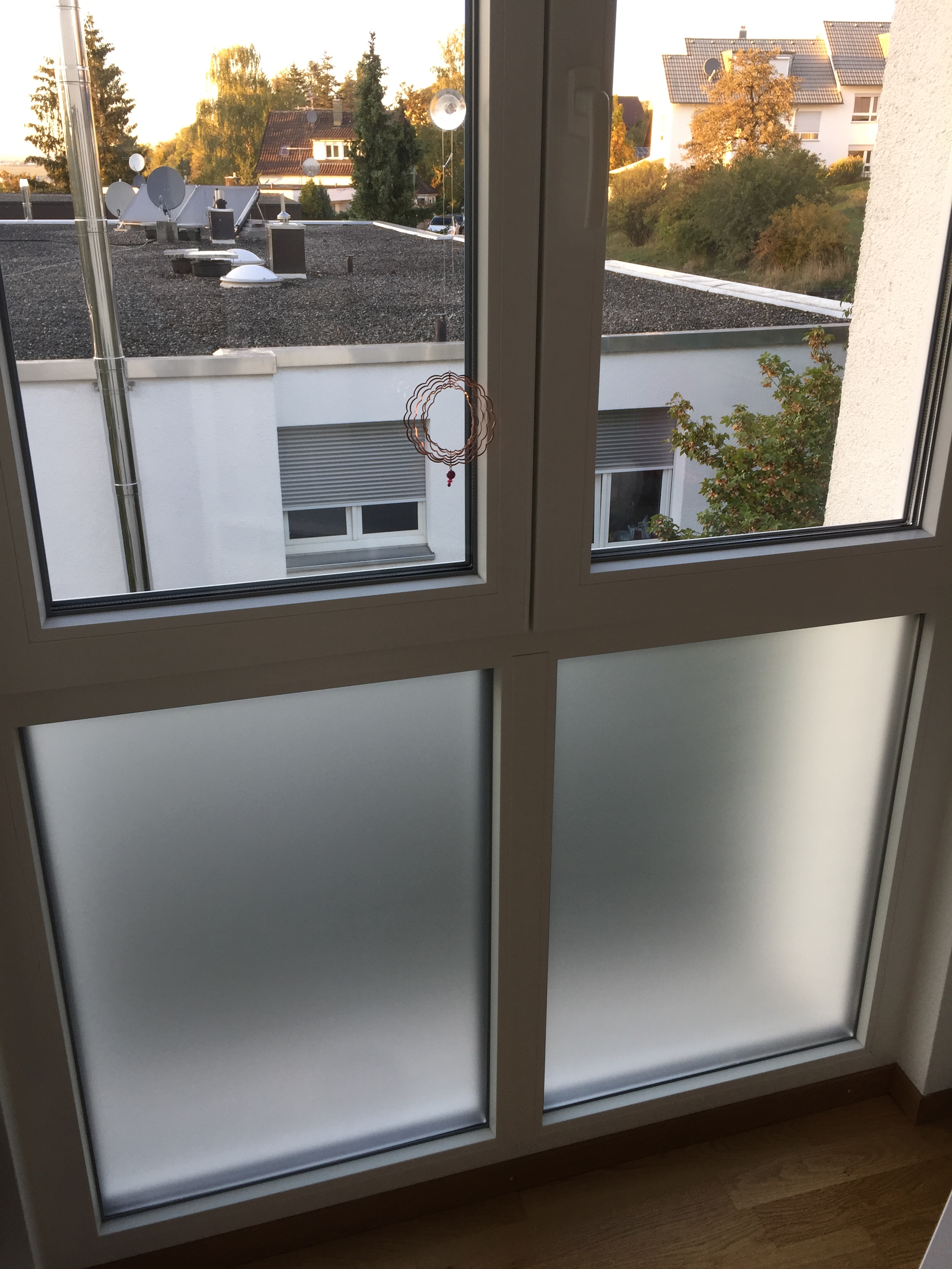 Weiß matte Adhäsionsfolie auf dem unteren Teil einer Fensterfront angebracht.