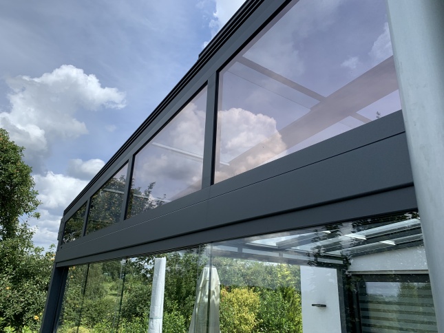 Mit der Sonnenschutzfolie bronze dunkel verspielt beklebte Fenster einer Terassenüberdachung - Außenansicht