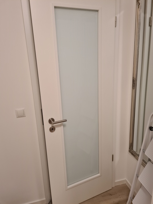 Weiße Verdunkelungsfolie auf einem Türausschnitt aus Glas