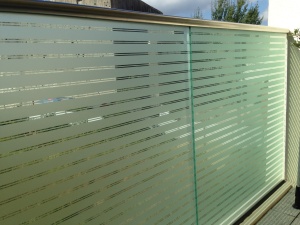 Dekorfolie, transparente in 3mm und 30mm dicken Streifen auf einer Balkonbrüstung