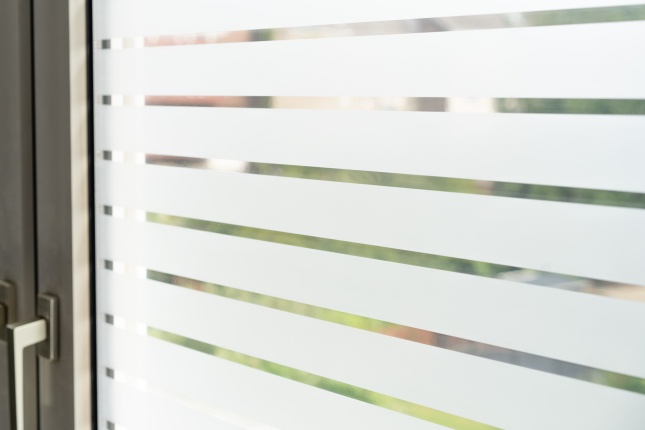 Weiß matte Streifenfolie auf einem Fenster montiert in der Nahaufnahme
