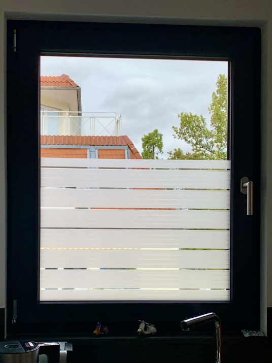 Adhäsionsfolie im Streifendesign auf Küchenfenster