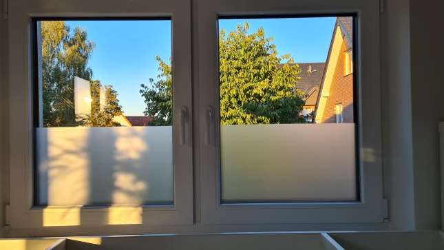 Selbsthaftende Sichtschutzfolie an Fenstern angebracht