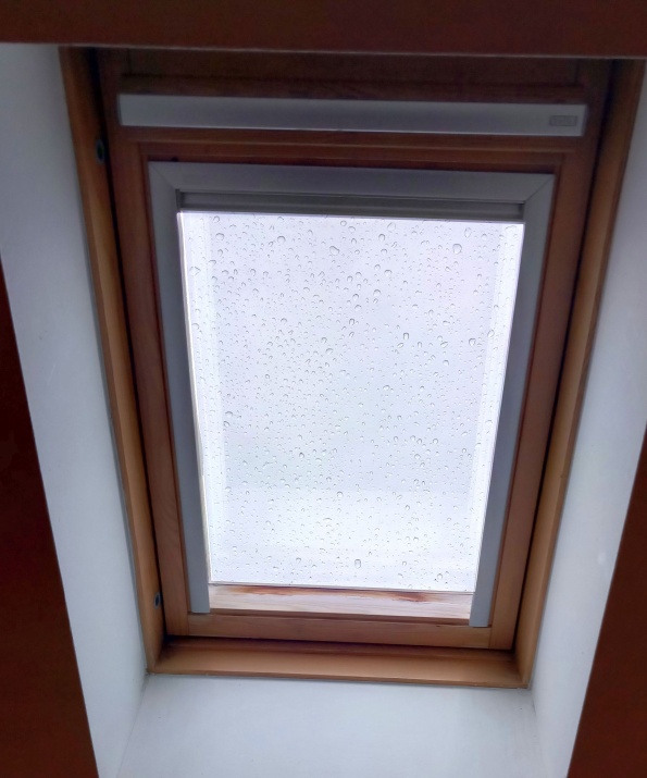 Sonnenschutzfolie in silber dunkel verspiegelt auf einem Dachfenster