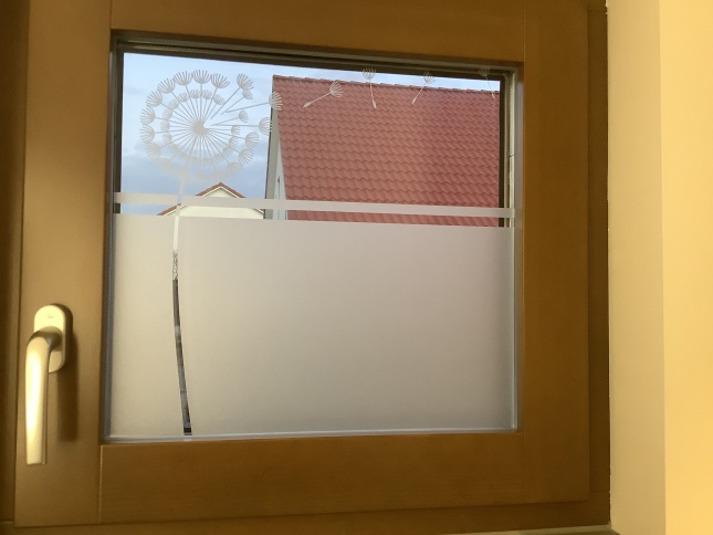 Pusteblume als Glasdekor auf einem kleinen Fenster