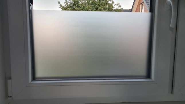 Selbsthaftende Sichtschutzfolie auf der unteren Hälte eines Fenster angebracht
