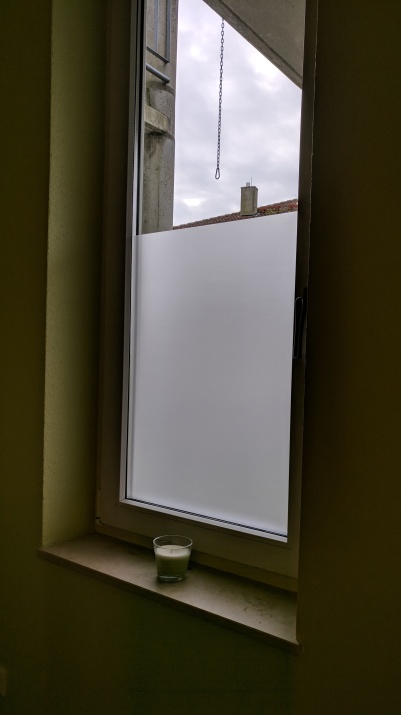 Selbsthaftende Sichtschutzfolie als teilbeklebung auf einem großen Fenster.