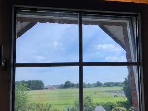 Sonnenschutzfolie silber dunkel auf einem Fenster unter dem Spitzdach