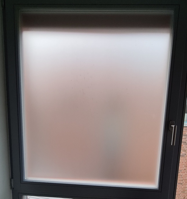 selbsthaftende Sichtschutzfolie in weiß auf ein Fenster foliert