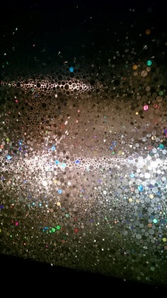 Selbsthaftende Folie in Kreis- Glanzoptik zu sehen bei Dunkelheit.