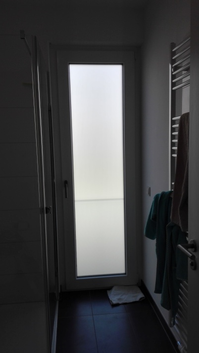 Kleberlose Sichtschutzfolie auf einem großen Badezimmerfenster angebracht.