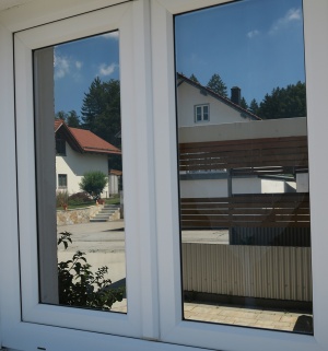 Außenansicht einer spiegelnden Sonnenschutzfolie auf zwei Fenstern