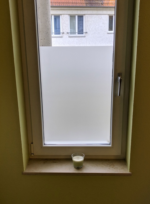 Adhäsionsfolie in Teilbeklebung als Sichtschutz auf einem großen Fenster angebracht.