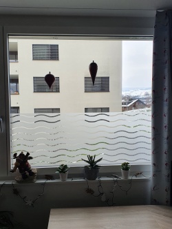 Dekorative Fensterfolie in Wellenoptik halbhoch auf einem Fenster angebracht