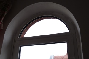 Ein Rundfenster vor der Montierung einer Sonnenschutzfolie