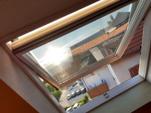 Silberne Sonnenschutzfolie auf einem Dachfenster angebracht