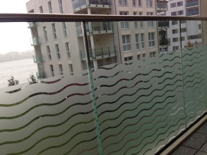 Dekorfolie transparent weiße Wellen als Sichtschutz eines Balkons.