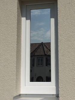 Sonnenschutzfolie silber dunkel verspiegelt auf einem schmalen Fenster mit Außenansicht
