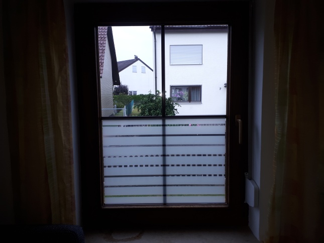Horizontale Streifenfolie die halbhoch auf einem Fenster angebracht wurde.