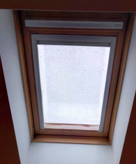 Sonnenschutzfolie in silber dunkel verspiegelt auf einem Dachfenster