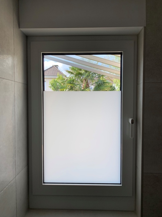 Kleberlose, weiß matte Folie als blickdichter Sichtschutz auf einem Fenster angebracht